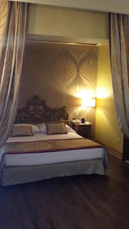a bedroom with a large bed with a canopy at Hotel Amadeus in Venice