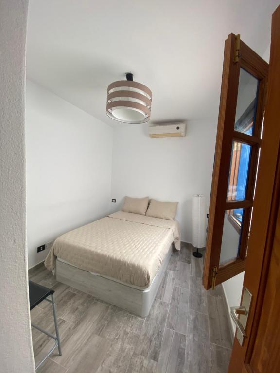 Dormitorio pequeño con cama y lámpara en Apartamento Bienestar en Playa Quemada