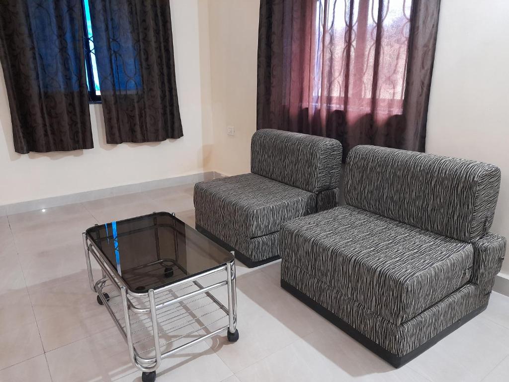 a living room with a couch and a chair at Raaj Inn studio's in Candolim