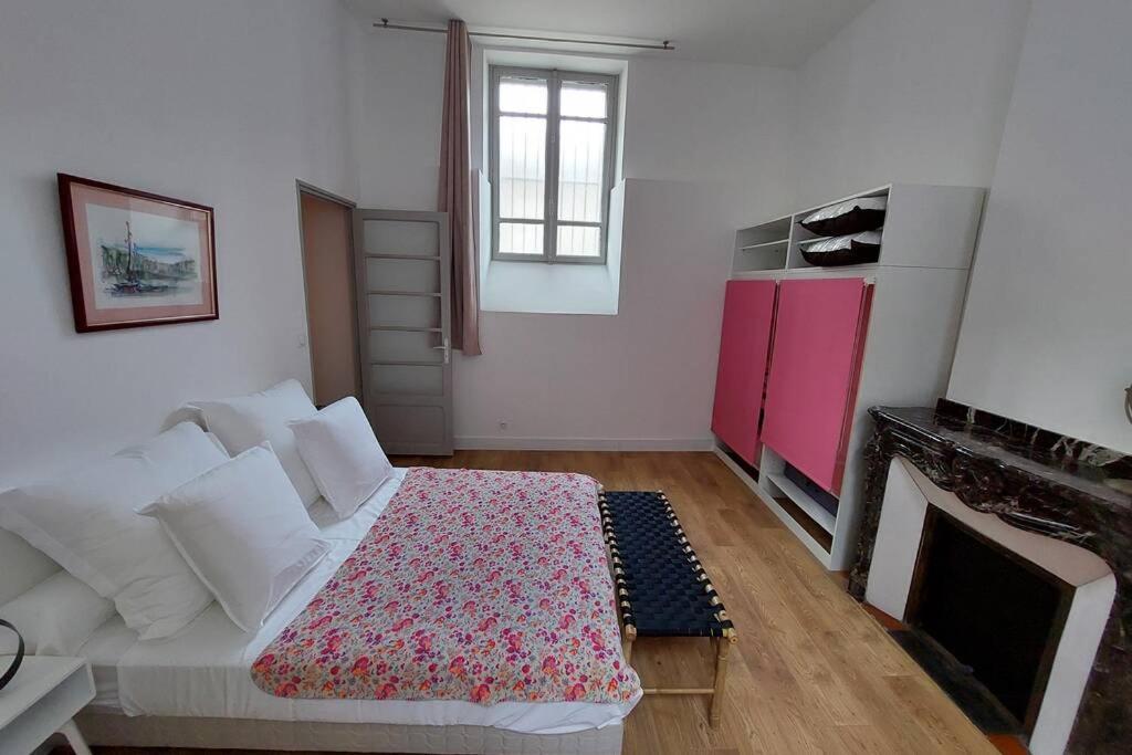 ein Wohnzimmer mit einem Bett und einem Kamin in der Unterkunft Les clématites in Narbonne