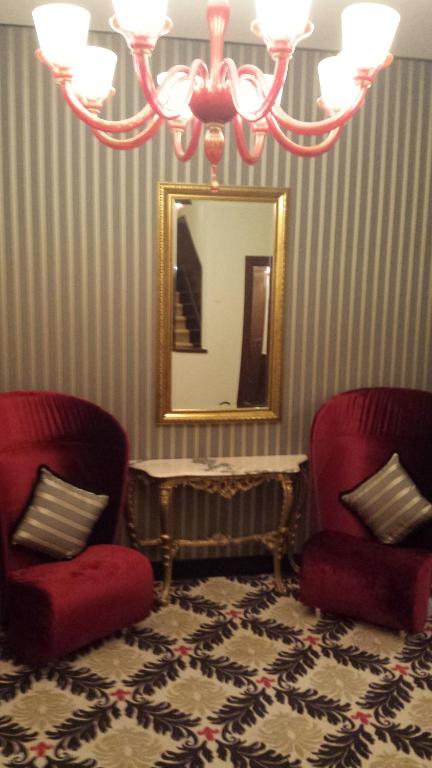 a living room with two chairs and a mirror at Hotel Amadeus in Venice