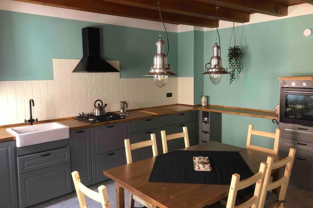 uma cozinha com uma mesa e cadeiras numa cozinha em Cá Greta em Chioggia