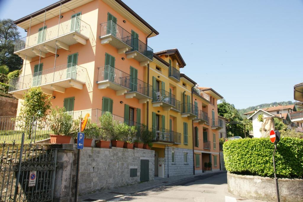 un edificio giallo con balconi su strada di Il Nuovo Palazzotto a Stresa