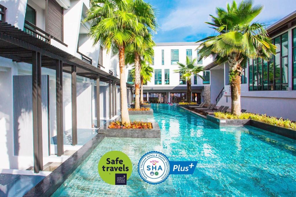 查汶的住宿－Chaweng Villawee Hotel - SHA Plus，一座楼前棕榈树游泳池