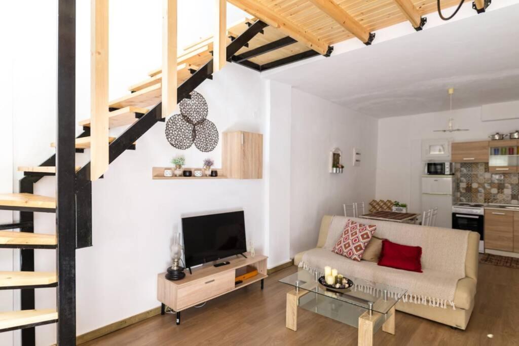 a living room with a couch and a tv at ARGY’S HOME in Alexandroupoli