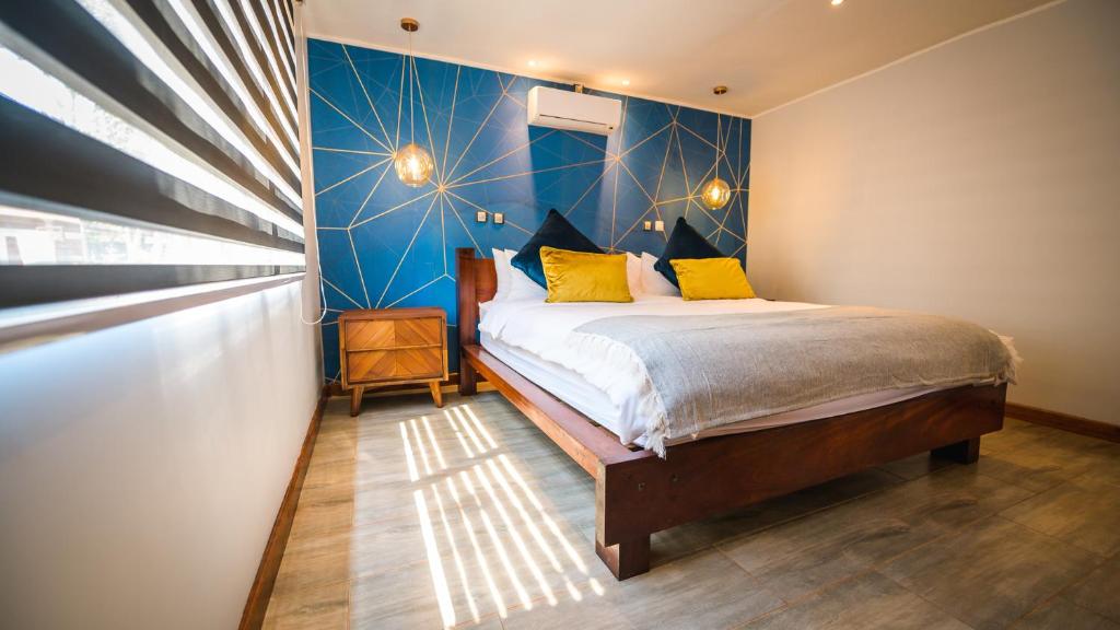 a bedroom with a bed and a blue wall at Kampi Ya Boma Kolwezi in Kolwezi