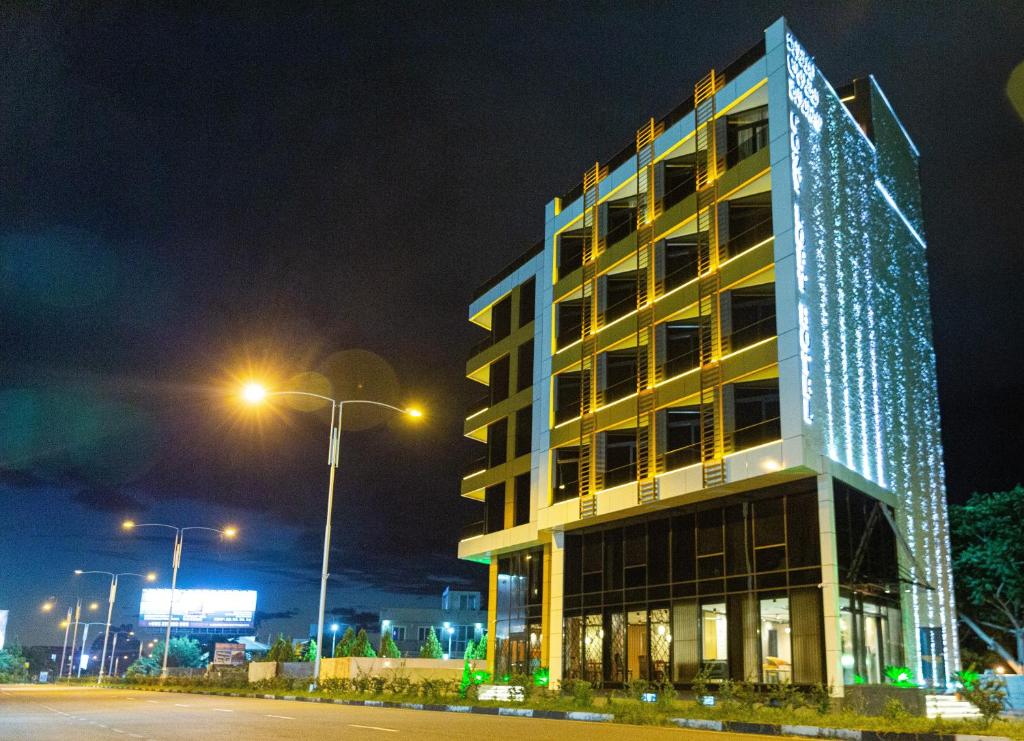 een hoog gebouw met 's nachts verlichting bij Cozy Loft Hotel in Batoemi