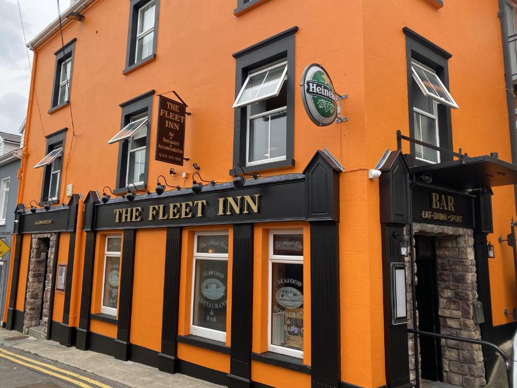 um edifício laranja com a pousada mais alta numa rua em The Fleet Inn em Killybegs