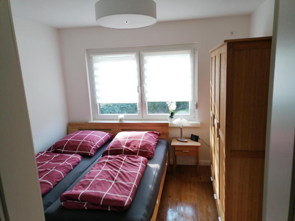 a bedroom with two beds and two windows at Ferienhaus Scandia am See in Warnitz