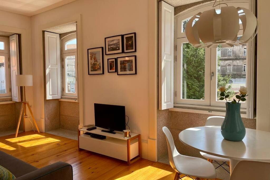 een woonkamer met een tafel en een televisie bij Santo António Cozy Apartment in Porto