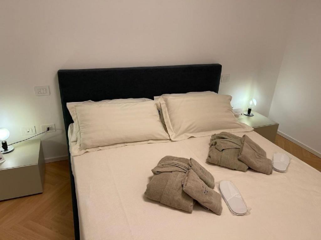 een bed met een witte sprei en een korte broek bij Number House - Number 10 in Milaan