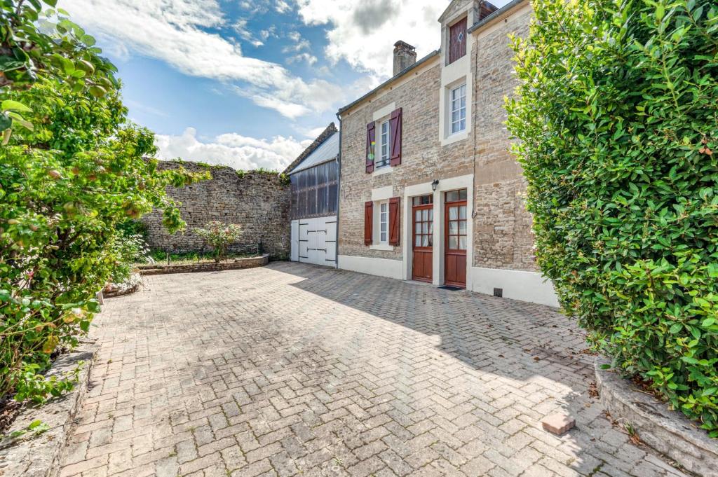 a stone driveway in front of a brick building at Hamo - Maison à 600 m de la plage in Graye-sur-Mer