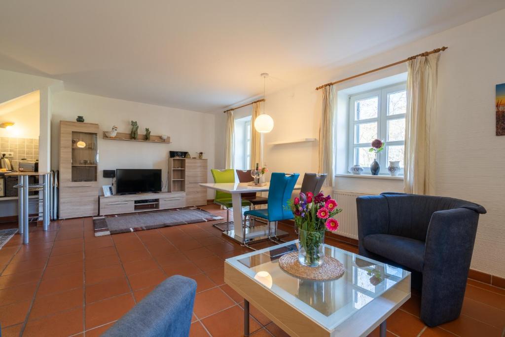 ein Wohnzimmer mit einem Tisch und Stühlen in der Unterkunft Feriendorf Rugana - Komfort Appartement mit 1 Schlafzimmern und Terrasse C39 in Dranske