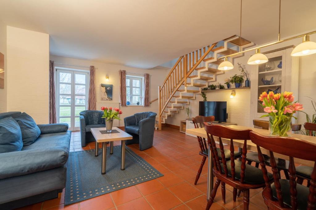 uma sala de estar com um sofá azul e uma mesa em Feriendorf Rugana - Klassik Appartement mit 2 Schlafzimmern und Terrasse C27 em Dranske