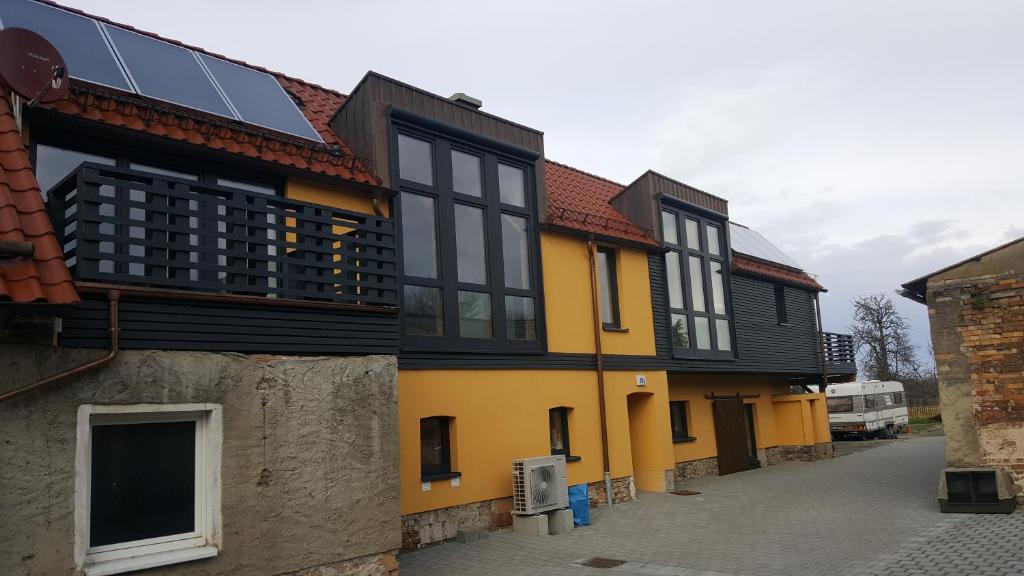 a yellow and black building with solar panels on it at Ferienwohnung auf dem Bauernhof in Großräschen