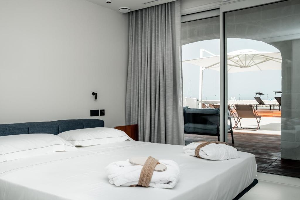 une chambre d'hôtel avec un lit et des serviettes. dans l'établissement Le 3 di Tuccino, à Polignano a Mare