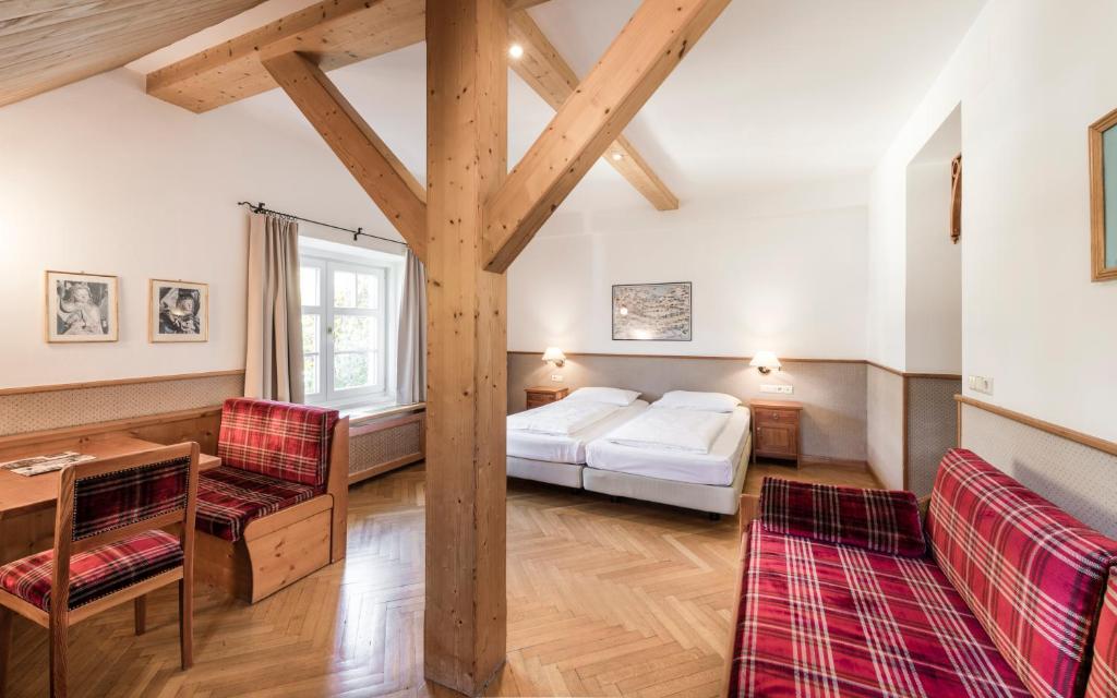 a bedroom with a bed and a table and chairs at Classic Hotel Am Stetteneck in Ortisei