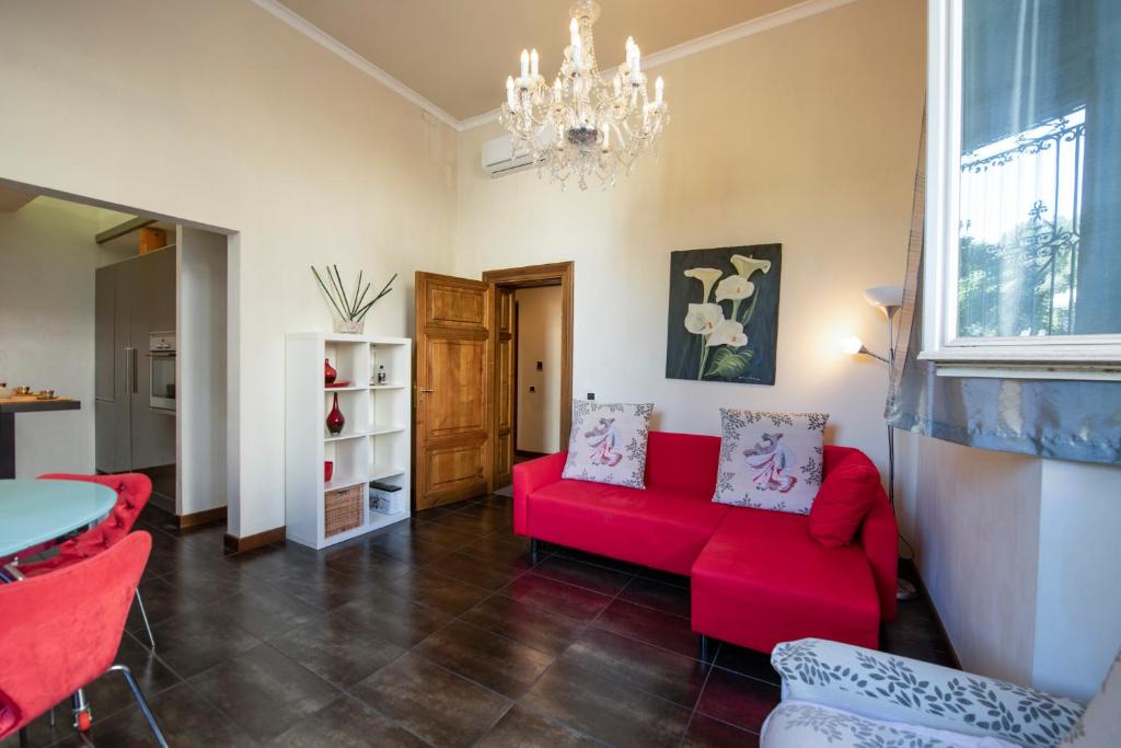 uma sala de estar com um sofá vermelho e um lustre em Mamo Florence - Indipendenza Apartment em Florença