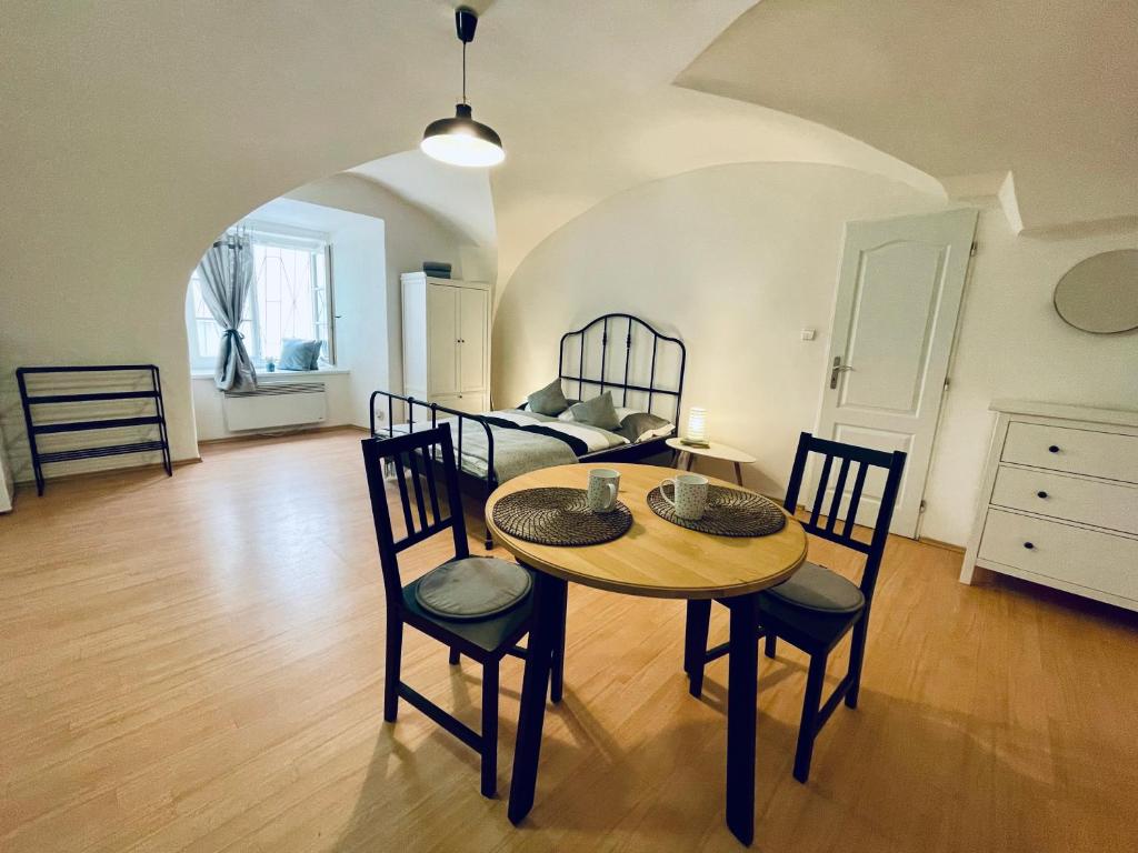 a room with a table and chairs and a bed at Studio Nicolas II Prague in Prague