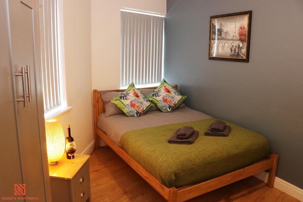 a small bedroom with a bed with two hats on it at Modern Newgate Apartments - Kingsbury Underground, All Local Amenities on Your Doorstep in Wealdstone