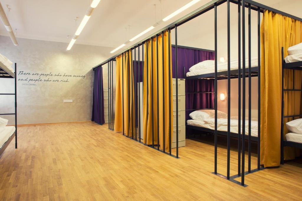 a room with two bunk beds and a hallway with wood floors at Hostel Tresor in Ljubljana