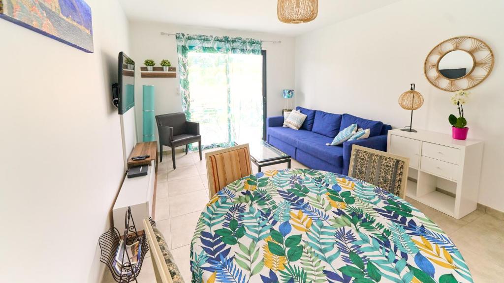 a living room with a blue couch and a table at Petite maison - annexe indépendante d'une villa / Independent Guesthouse within a villa in Corneilla-del-Vercol