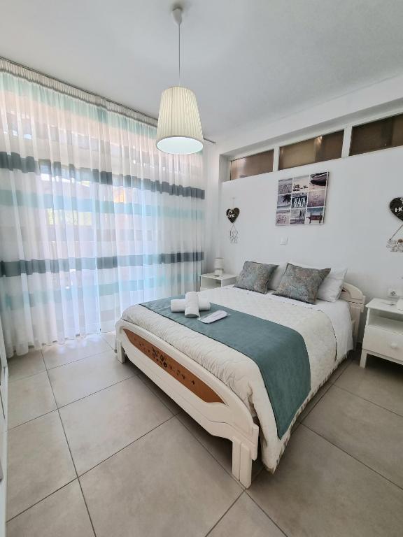 a white bedroom with a large bed and a table at Harmony Residence in Kavos