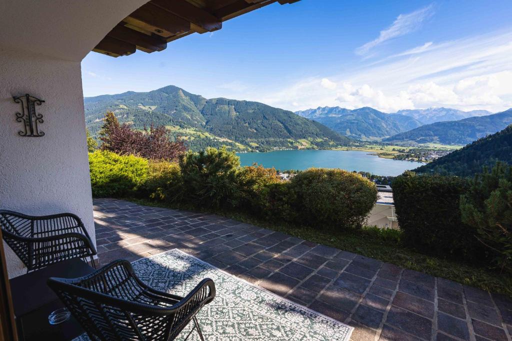 a patio with two chairs and a view of a lake at Chalet Crown of the Alps by we rent in Zell am See