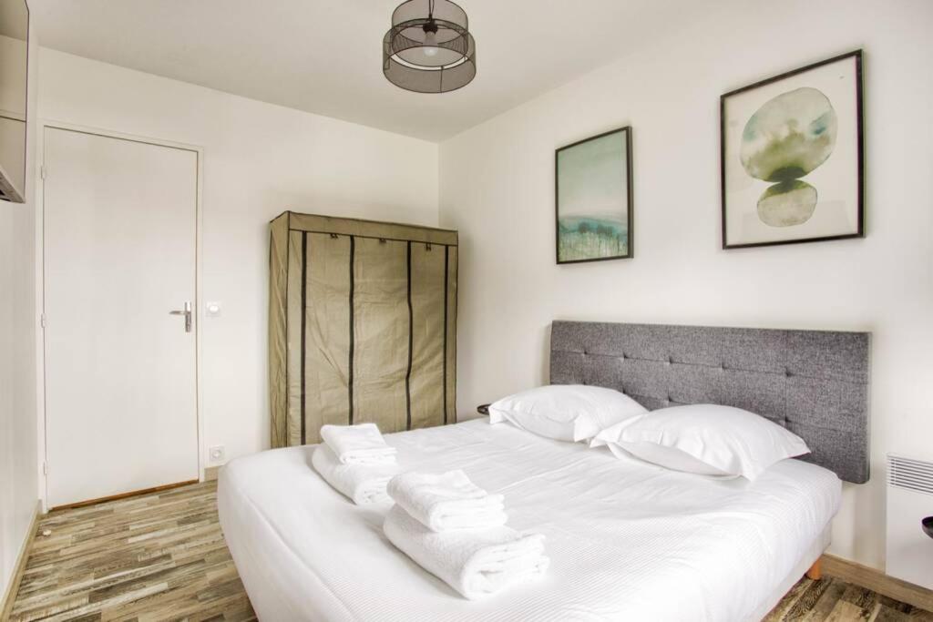 a bedroom with a large white bed with white pillows at Home Suite Home Blonville-Deauville in Blonville-sur-Mer
