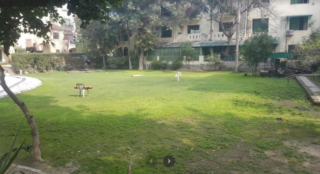 a large grassy yard in front of a building at Luxury 3 Bedrooms Apartment in Lahore