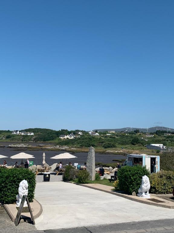a walkway with statues of lions and a body of water at Caisleain Oir Hotel in Annagry