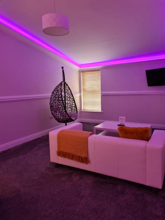a living room with a white couch and pink lighting at Caisleain Oir Hotel in Annagry
