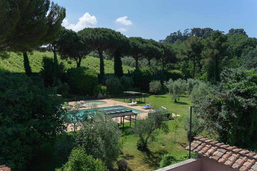 einen Blick über einen Garten mit Pool und Bäumen in der Unterkunft Frascati Country House in Grottaferrata