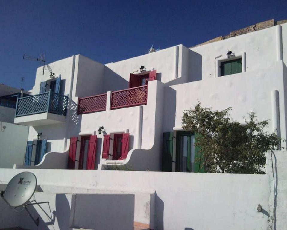 a white building with colorful doors and windows at Asvestoti maisonettes Blue house in Astypalaia Town