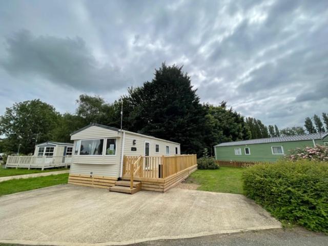 a mobile home with a deck and a house at Lakeside Holiday rentals - Trieste in Great Billing