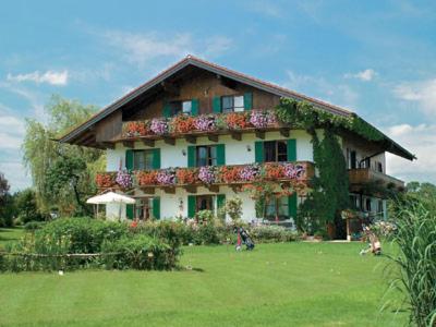 ein großes Haus mit Blumen auf der Vorderseite in der Unterkunft Gästehaus Bauer am Golfplatz in Prien am Chiemsee