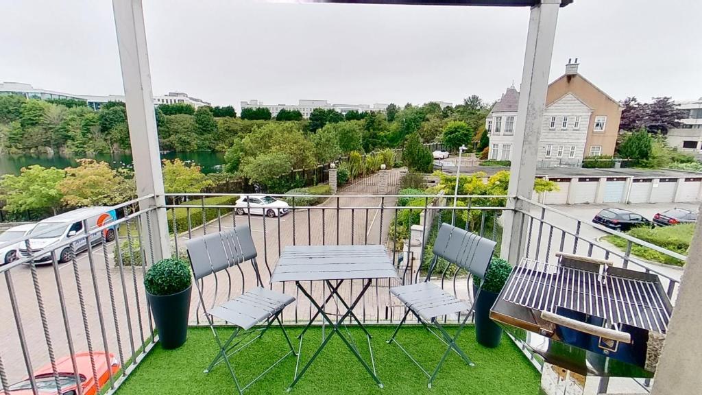 a balcony with chairs and a table and a view of a street at Orange Apartments Rubislaw Mansions in Aberdeen
