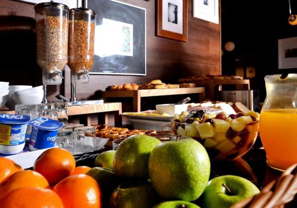 A colorful breakfast buffet with fruit, cereals, yogurt and pastries.