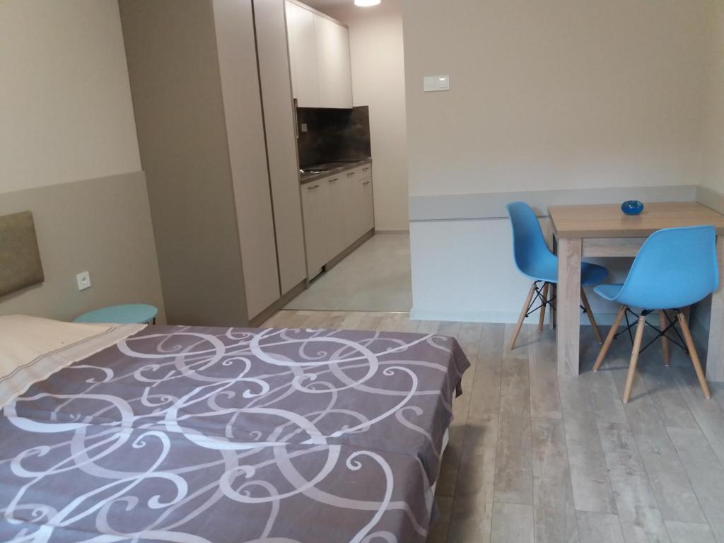 um quarto com uma cama, uma mesa e cadeiras em Студио Булаир 1 em Burgas