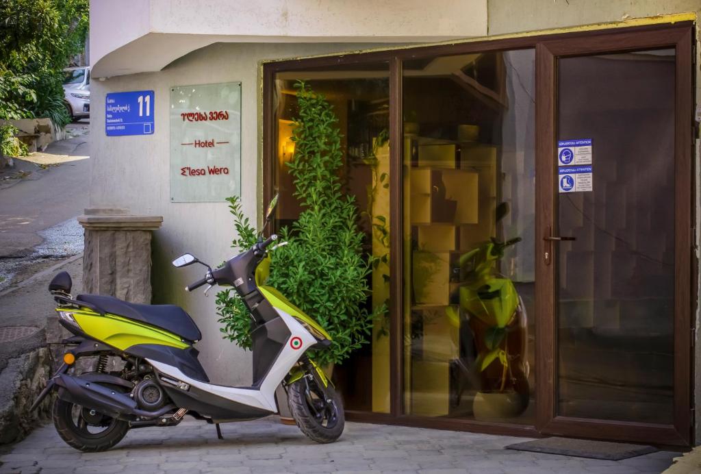 un scooter estacionado frente a un edificio en Hotel "Elesa Wera", en Tiflis