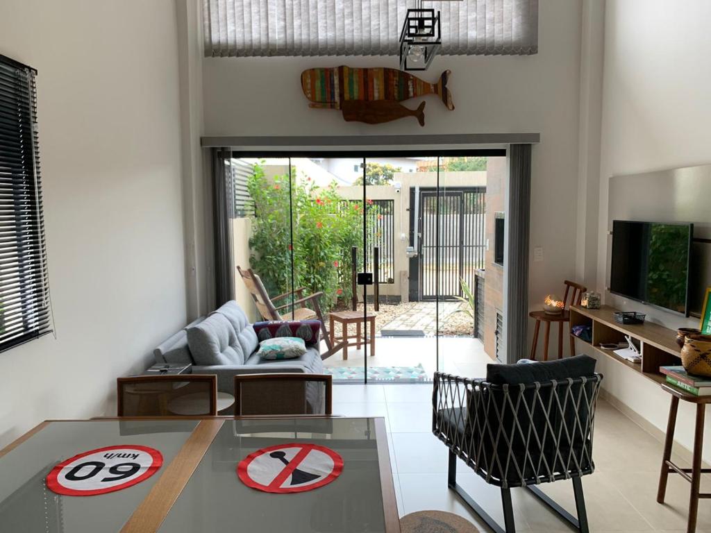 a living room with a table and a tv at Lindo Apartamento no Mariscal, Bombinhas, com estacionamento e quintal, a 290 metros da praia do Canto Grande!!! in Bombinhas