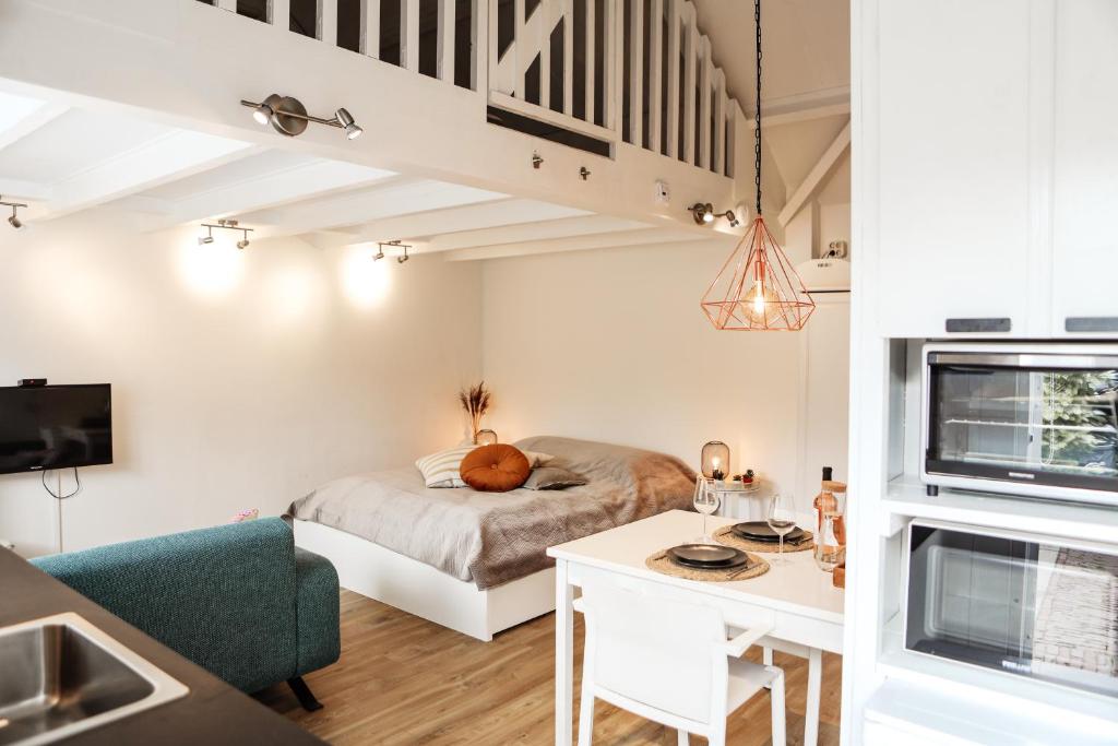 een klein appartement met een bed en een bureau in een kamer bij Morning Glory in Wemeldinge