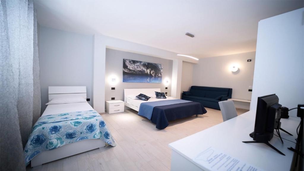 - une chambre avec un lit et un canapé dans l'établissement IsolaDino b&b sweet home, à Praia a Mare
