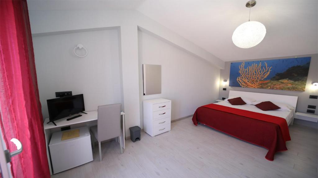 a bedroom with a bed and a desk with a computer at IsolaDino b&b sweet home in Praia a Mare