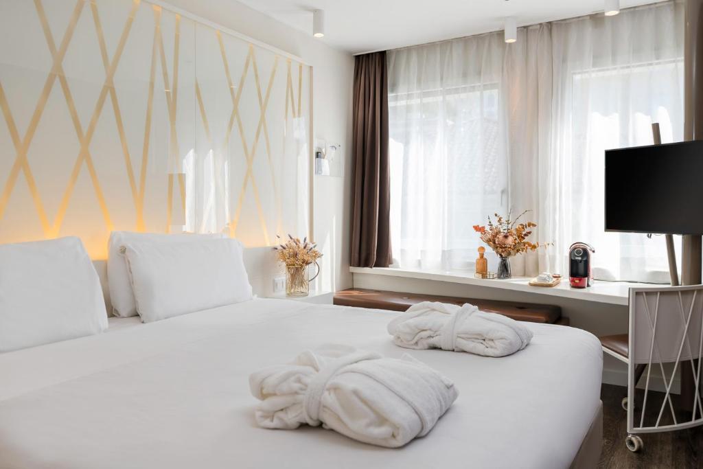 a bedroom with a white bed with towels on it at Hotel Admiral Lugano in Lugano
