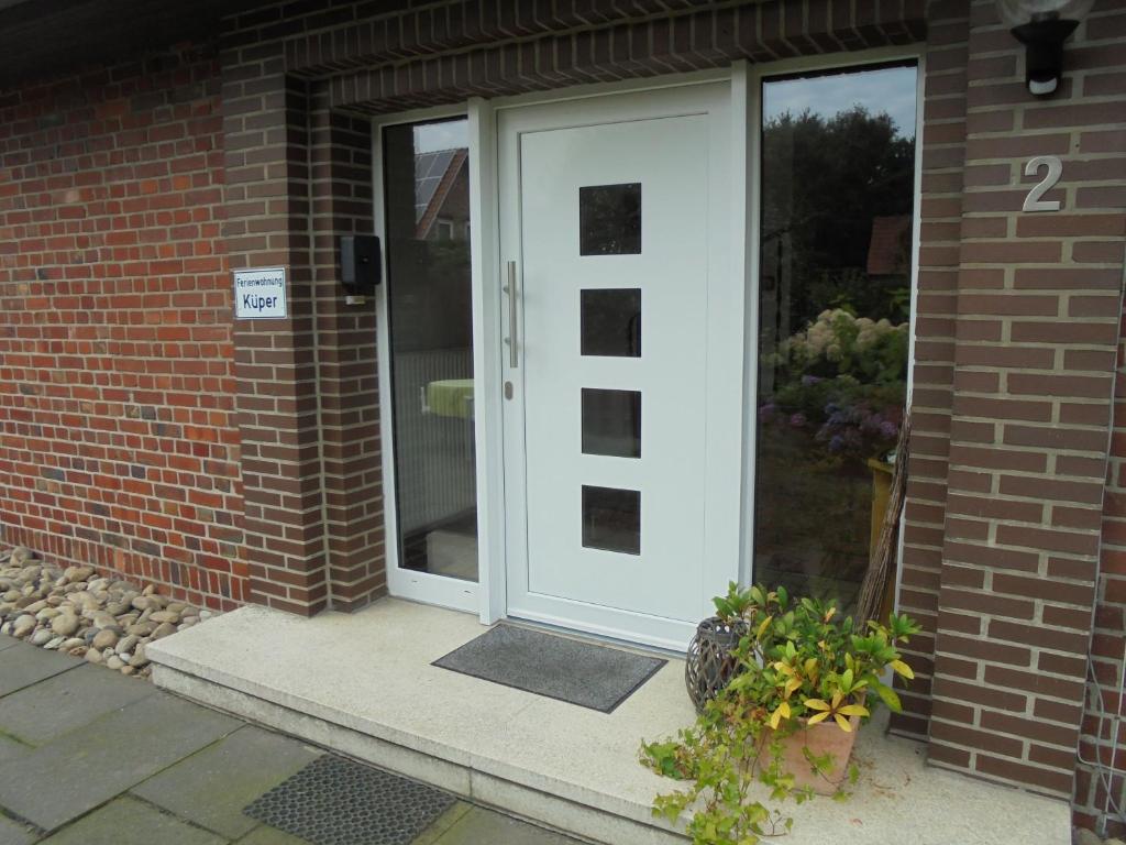 a white front door of a brick house at Ferienwohnung Küper in Getelo