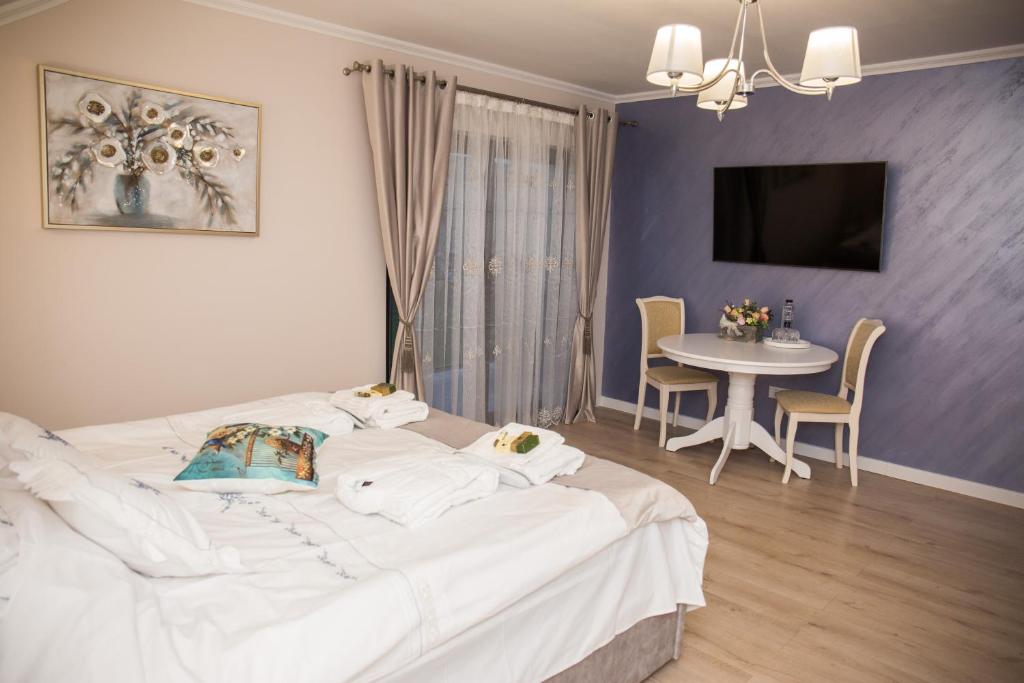 a bedroom with a large white bed and a table at Seara pe deal in Coruşu