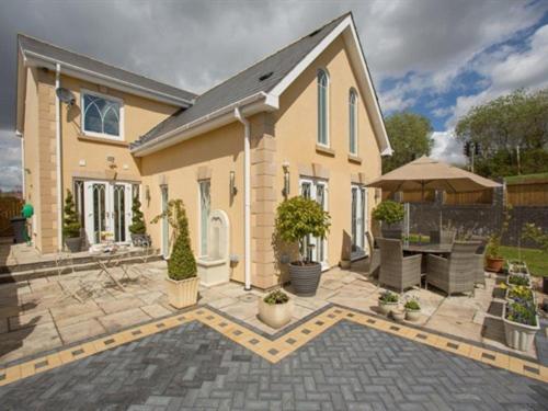 a large house with a patio in front of it at Queen Bee & B in Merthyr Tydfil