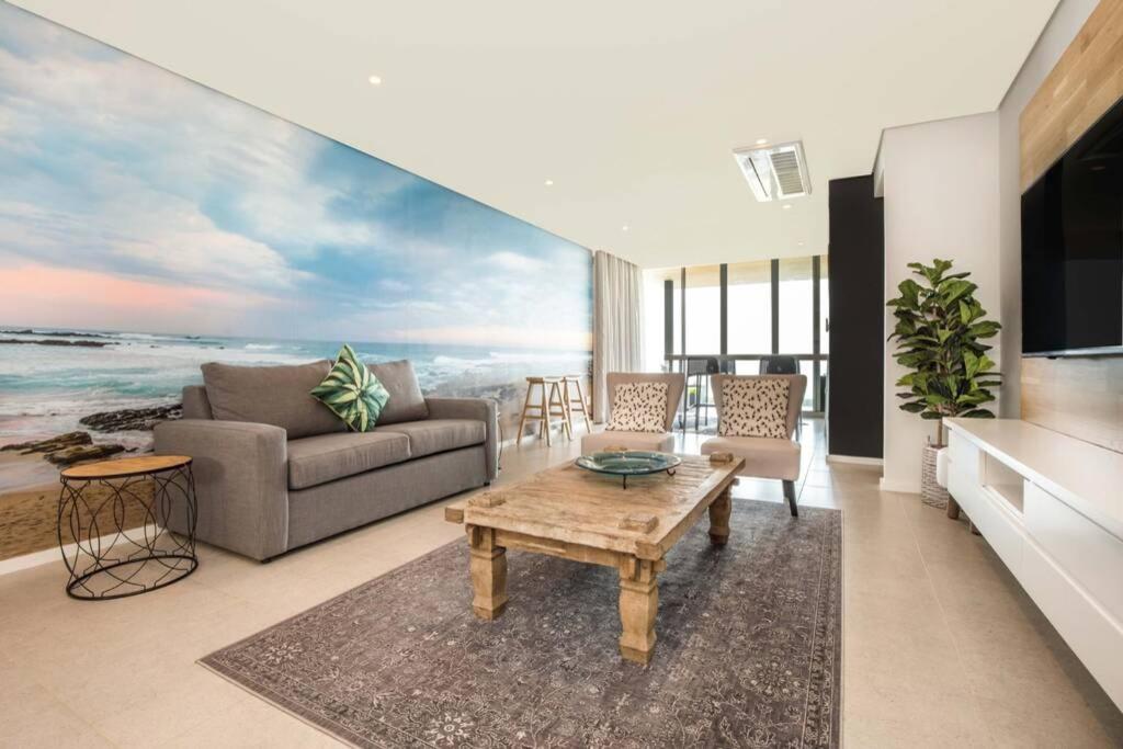ein Wohnzimmer mit einem Sofa und einem Tisch in der Unterkunft Ocean Dune Luxury Apartment 411 in Umhlanga