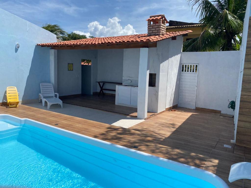 a villa with a swimming pool next to a house at Casa Frida Aracaju a 500m da praia in Aracaju